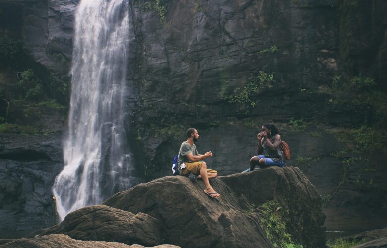couple-Language-study-waterfall a couple next to a big waterfall and sat on a rock
